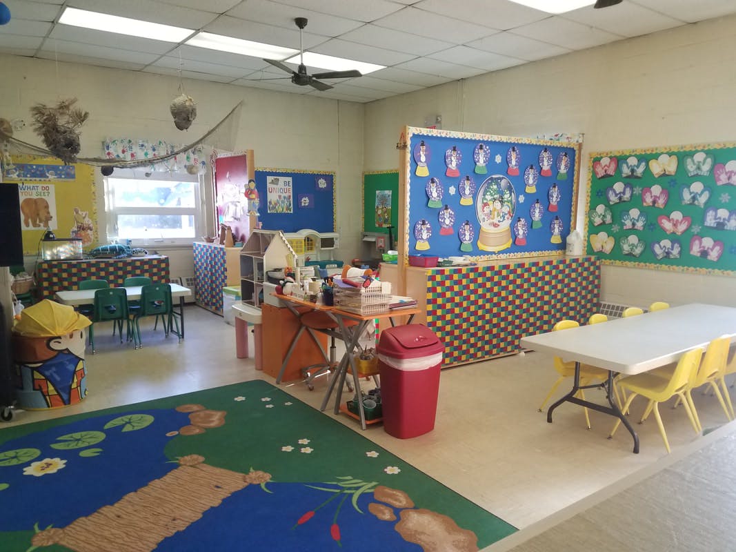 Empty classroom with tables, chairs, and decorated bulletin boards