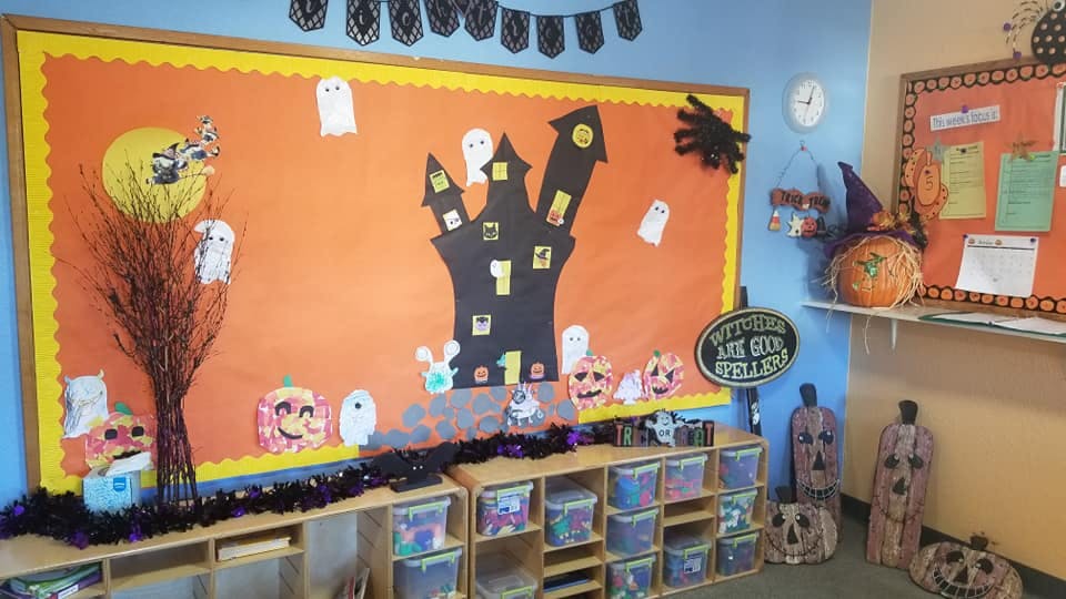 Halloween-themed bulletin board with haunted house and ghosts