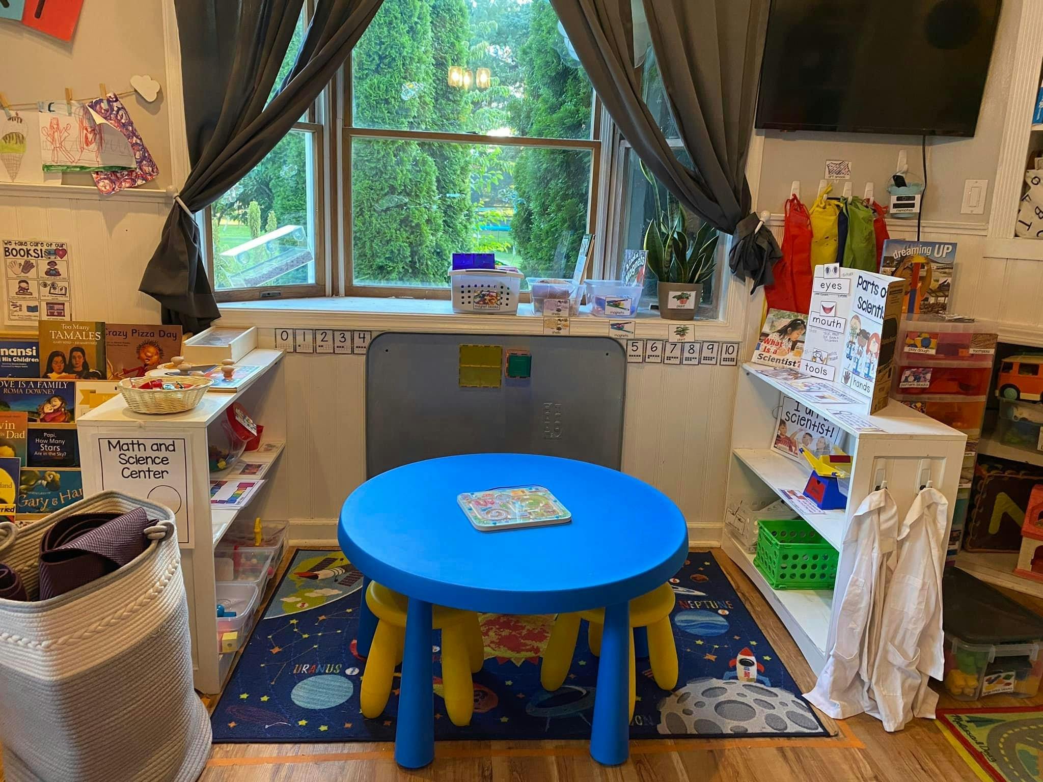 Child's blue table and chairs in a room with shelves of books and toys