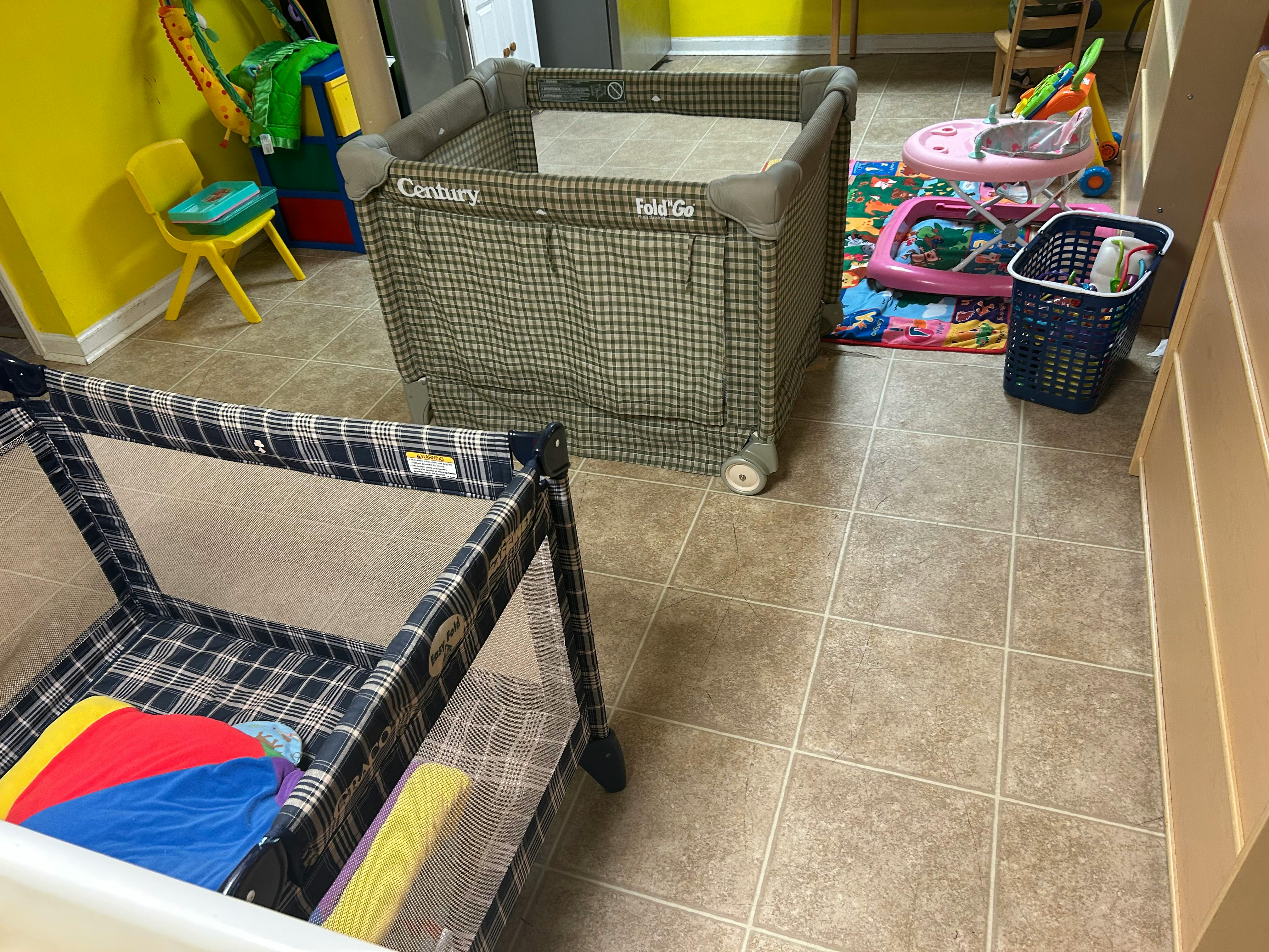 Two playpens in a room with yellow walls