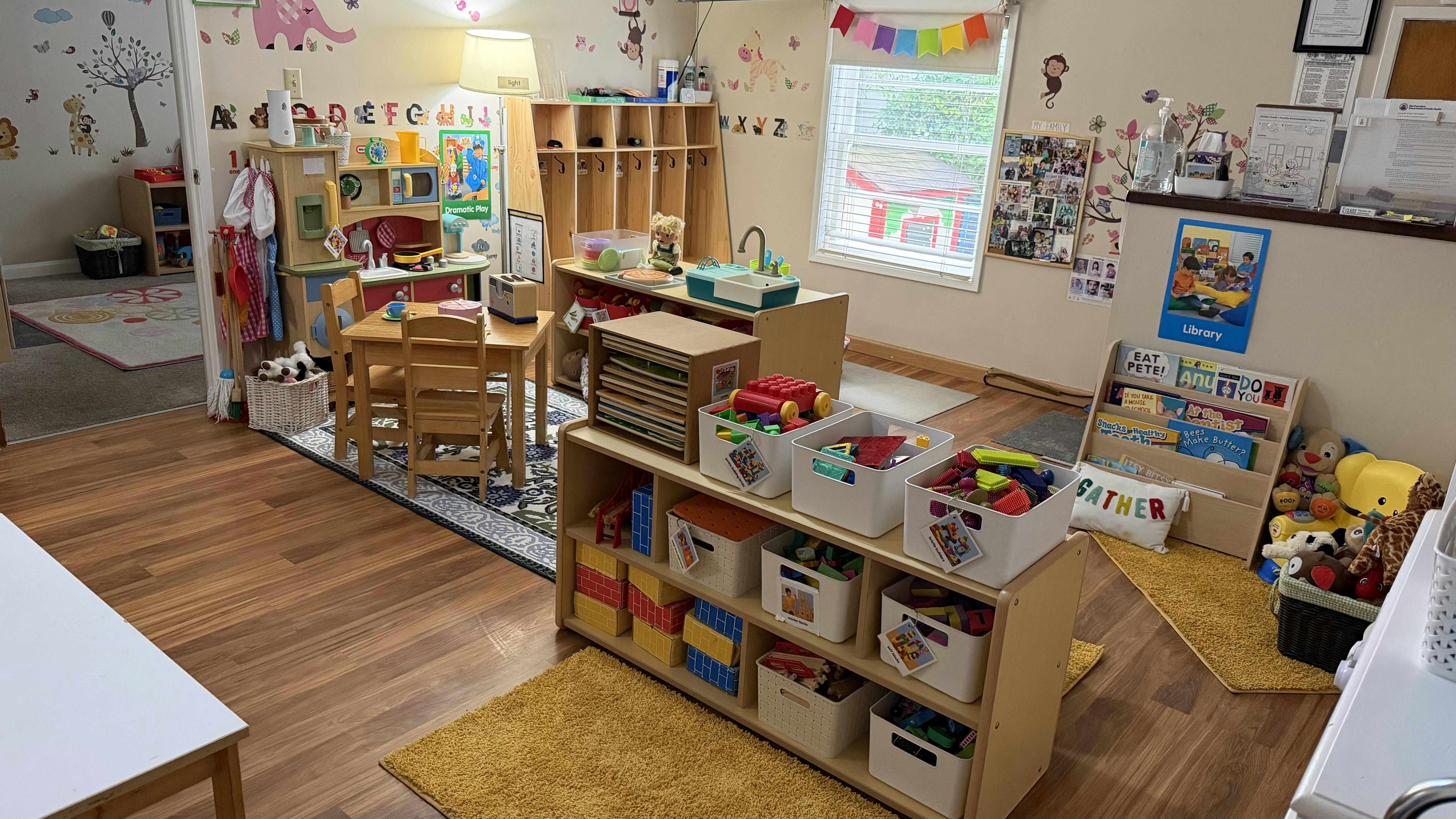 Classroom interior with play kitchens, toy shelves, and books