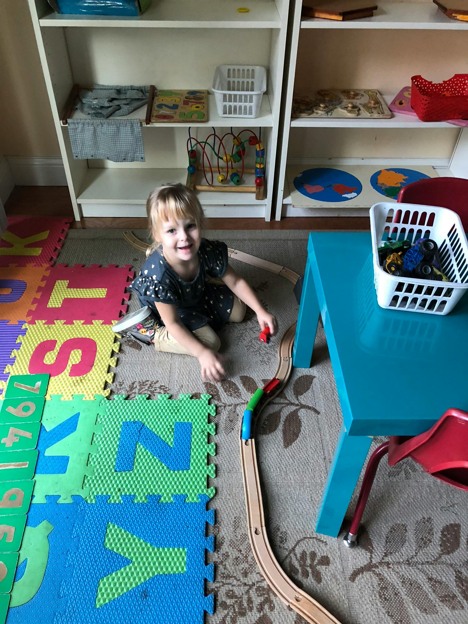 Child playing with a toy train on the floor