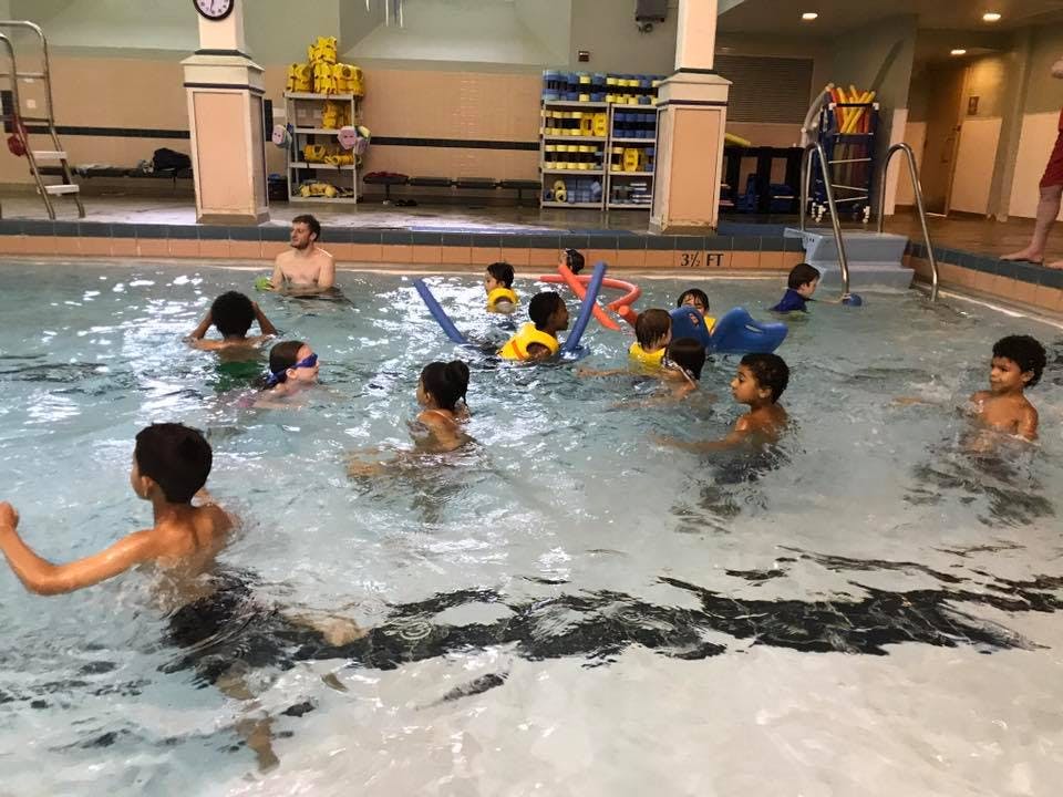 Children and an adult in a swimming pool