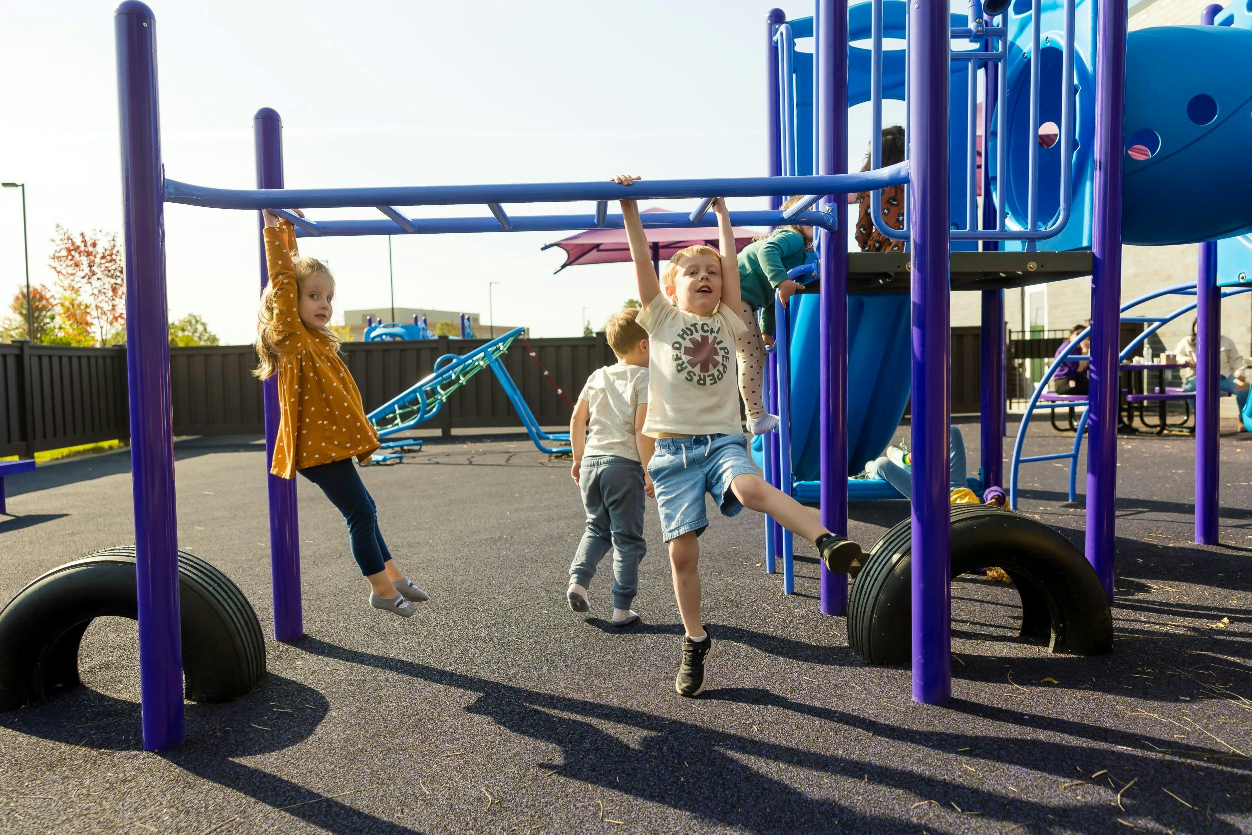 Children playing on monkey bars and playground equipment