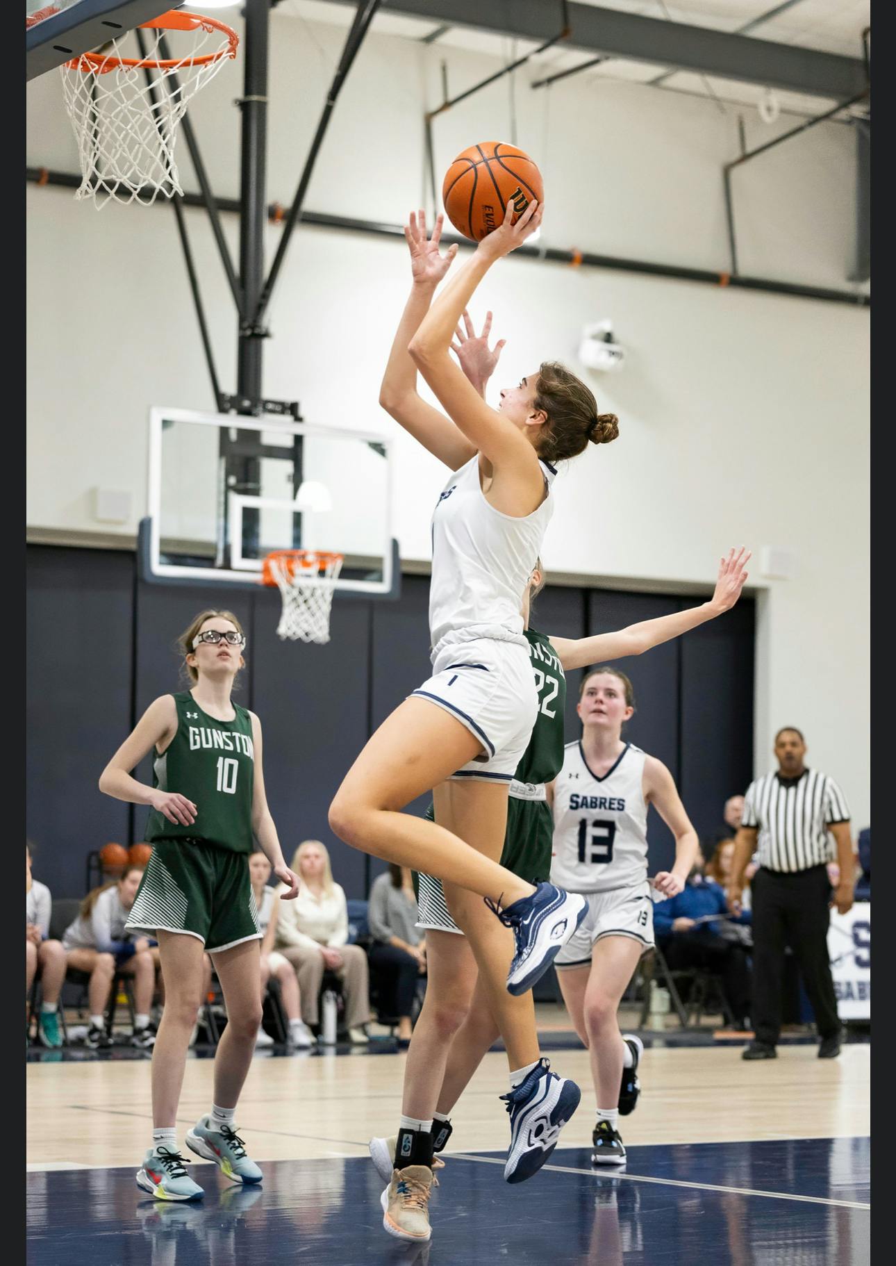 Teen basketball player jumping to shoot a basketball