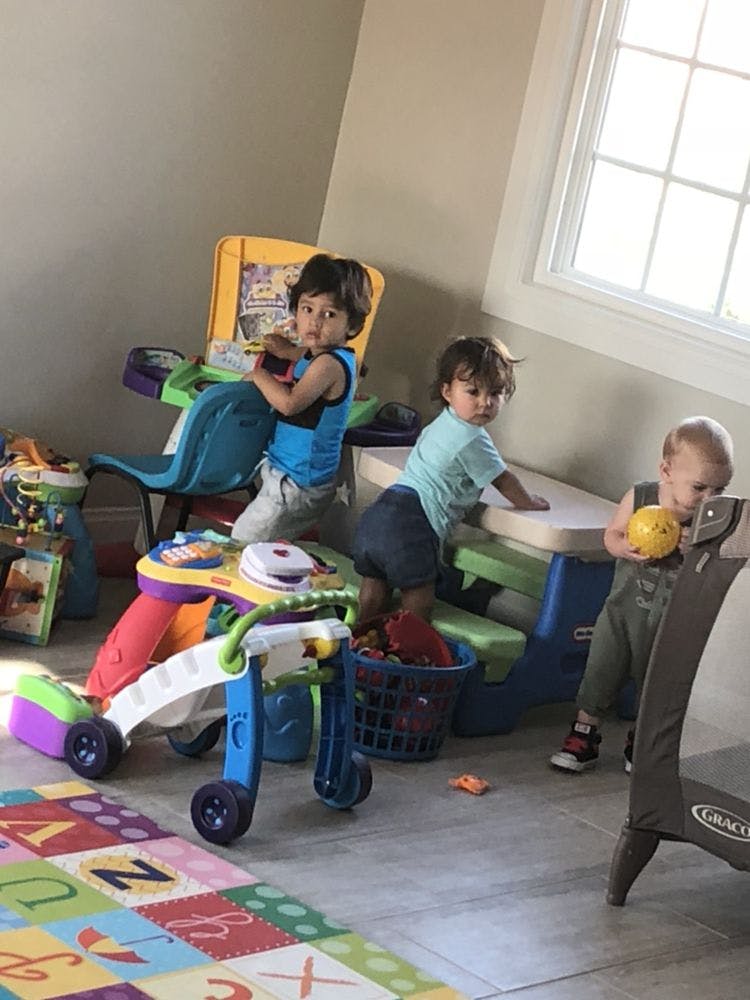 Three children playing with toys in a room