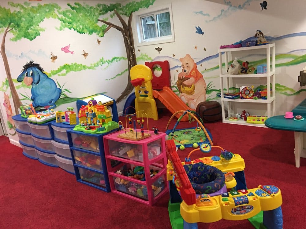 Playroom with toys, storage bins, and wall murals