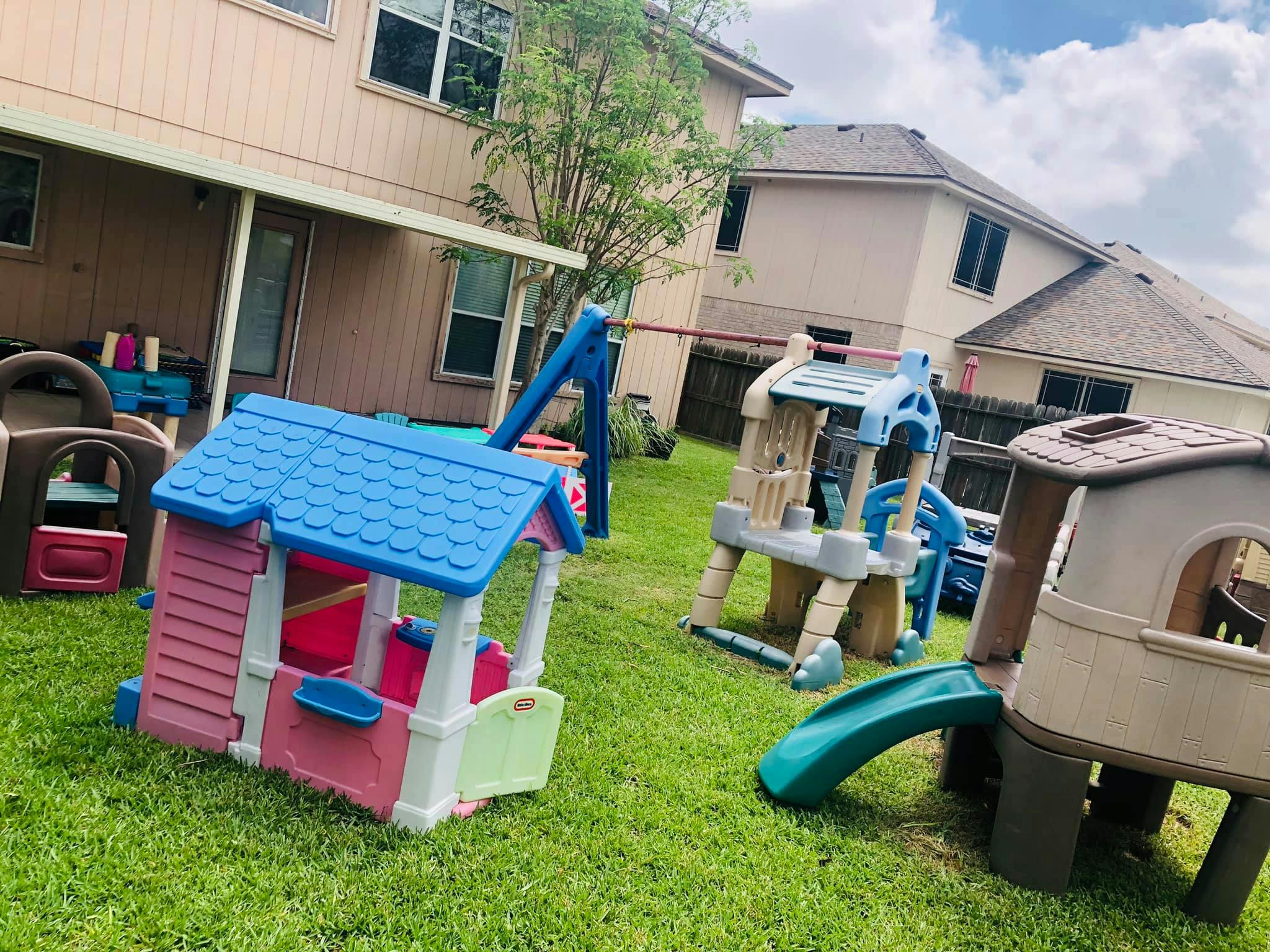 Playhouses and slides in a grassy backyard