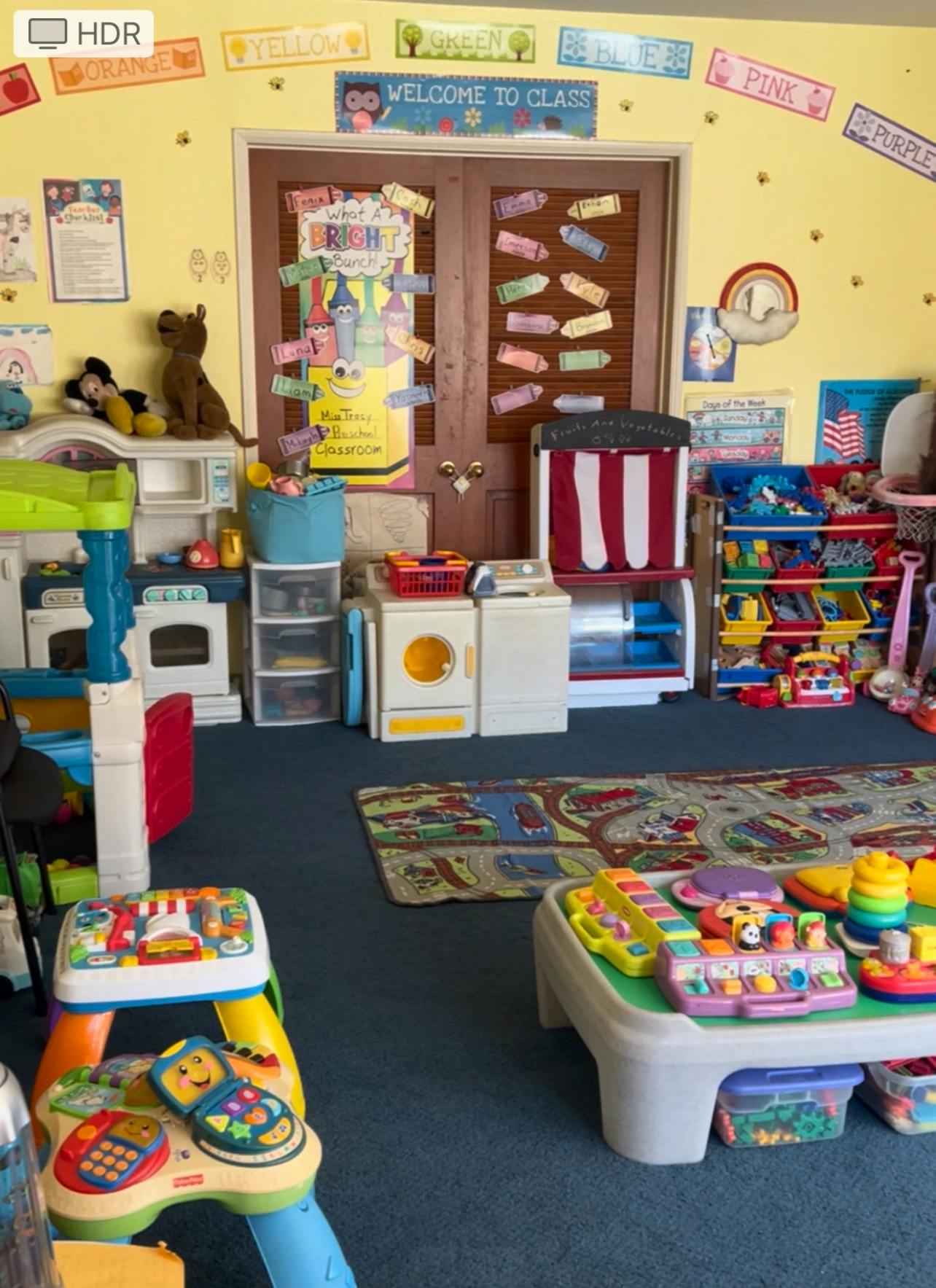 Playroom with various toys and a "Welcome to Class" sign above a door