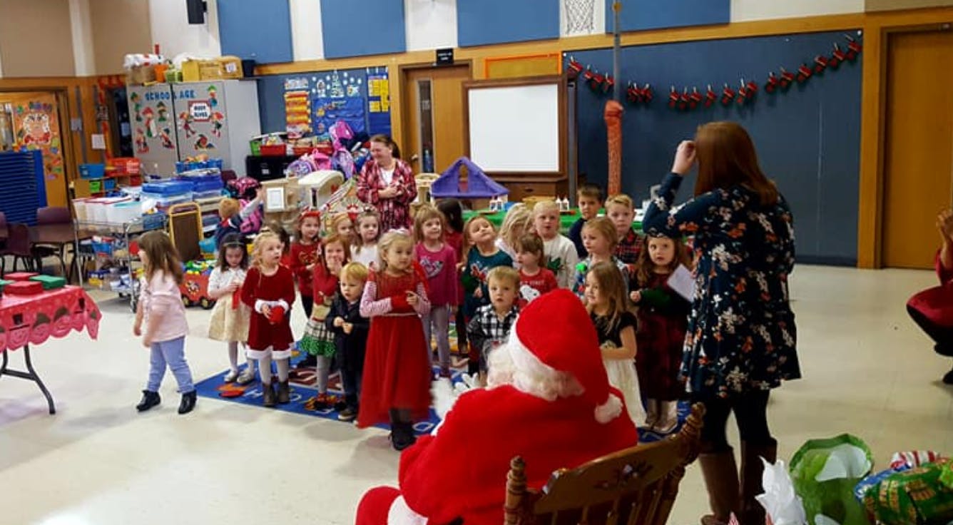 Santa Claus with a group of children and adults in a room