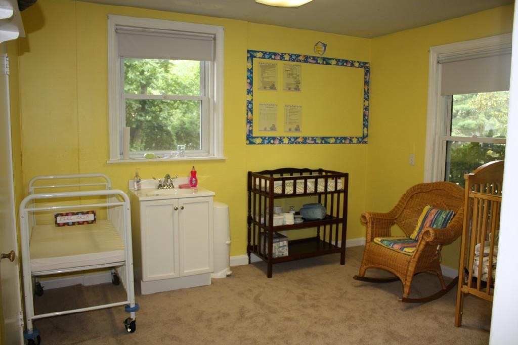 Nursery room with cribs, changing table, and rocking chair