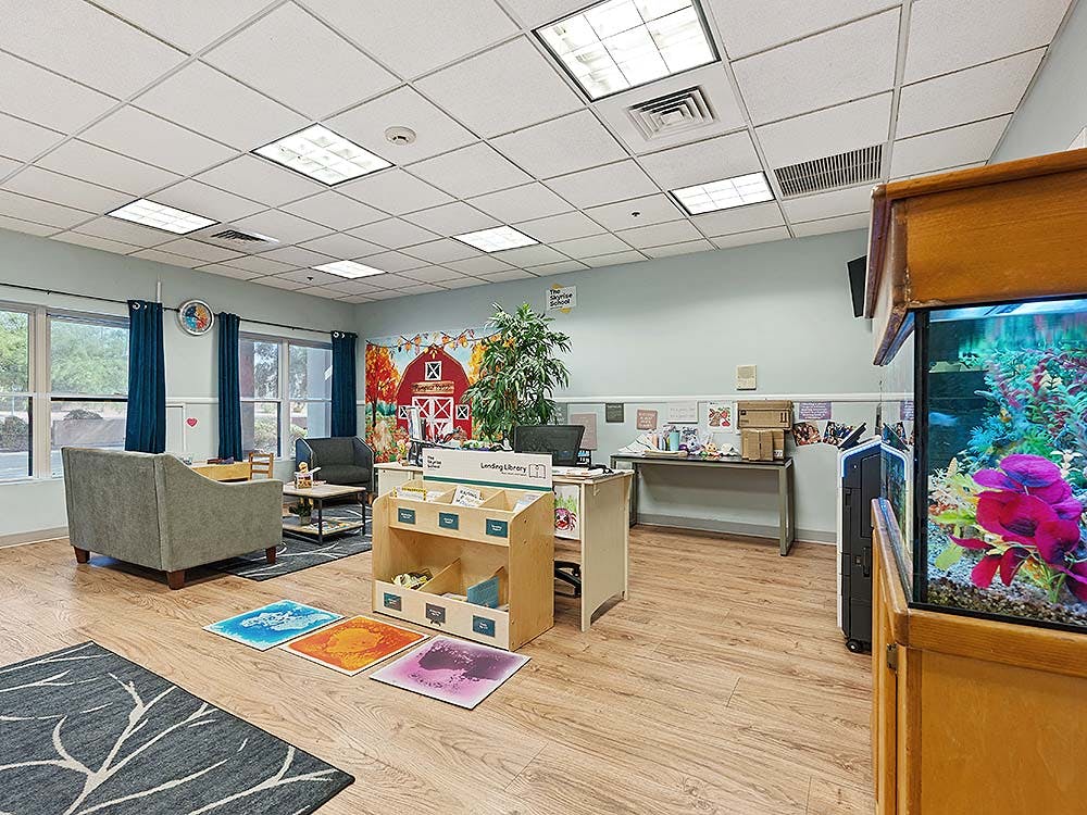 Lounge area in a school classroom with a fish tank and lending library