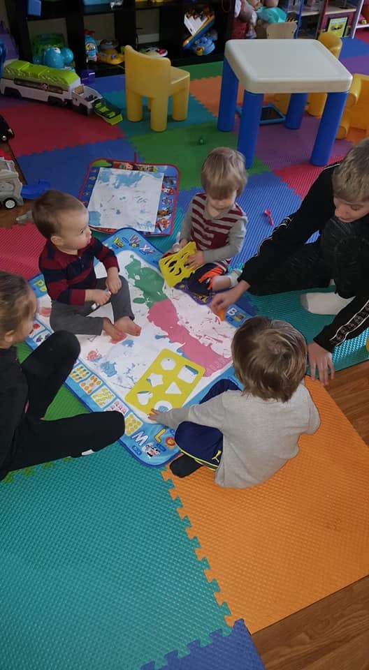 Children playing with toys on a colorful mat