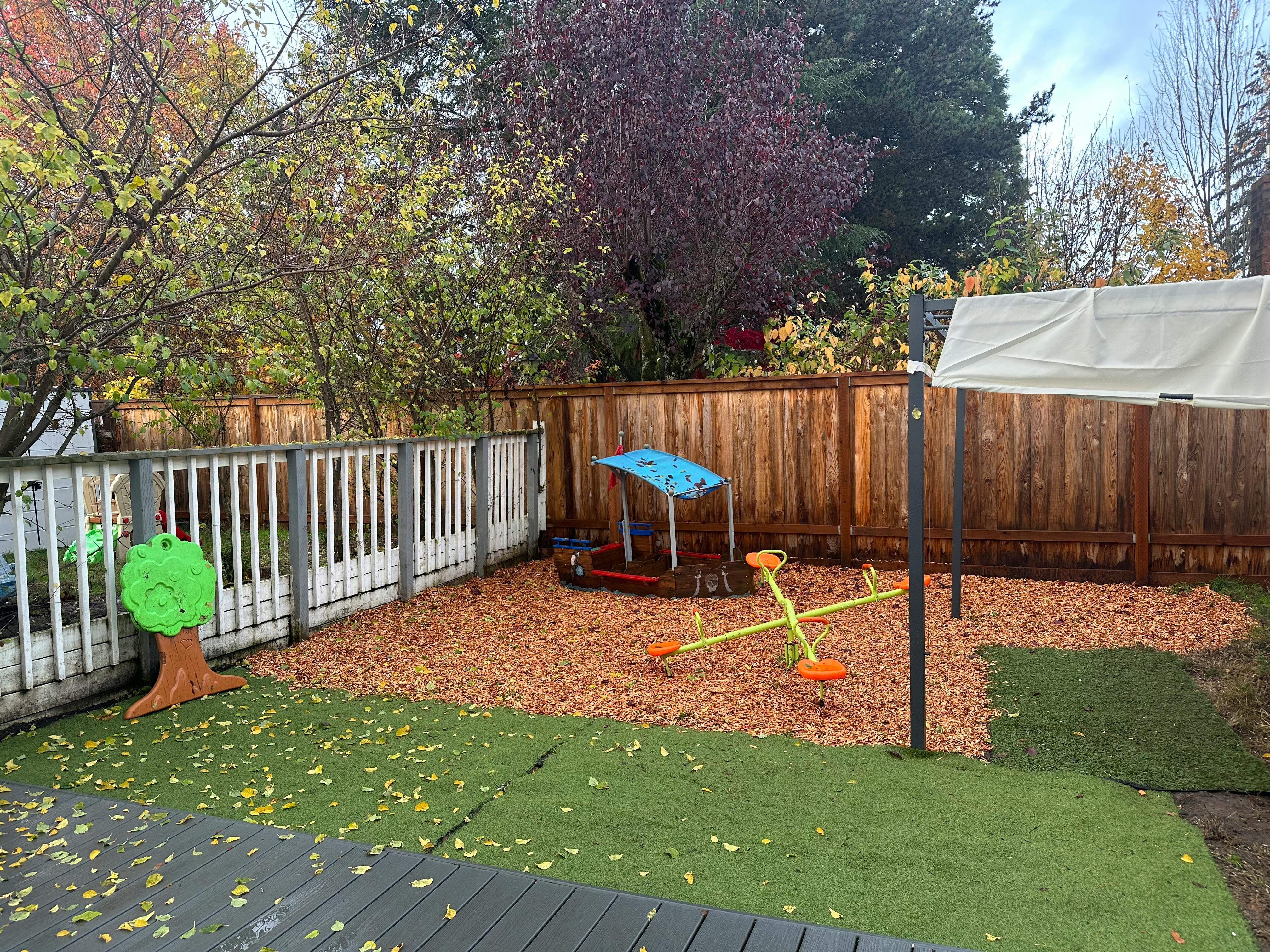 Backyard playground with a seesaw and wood chips