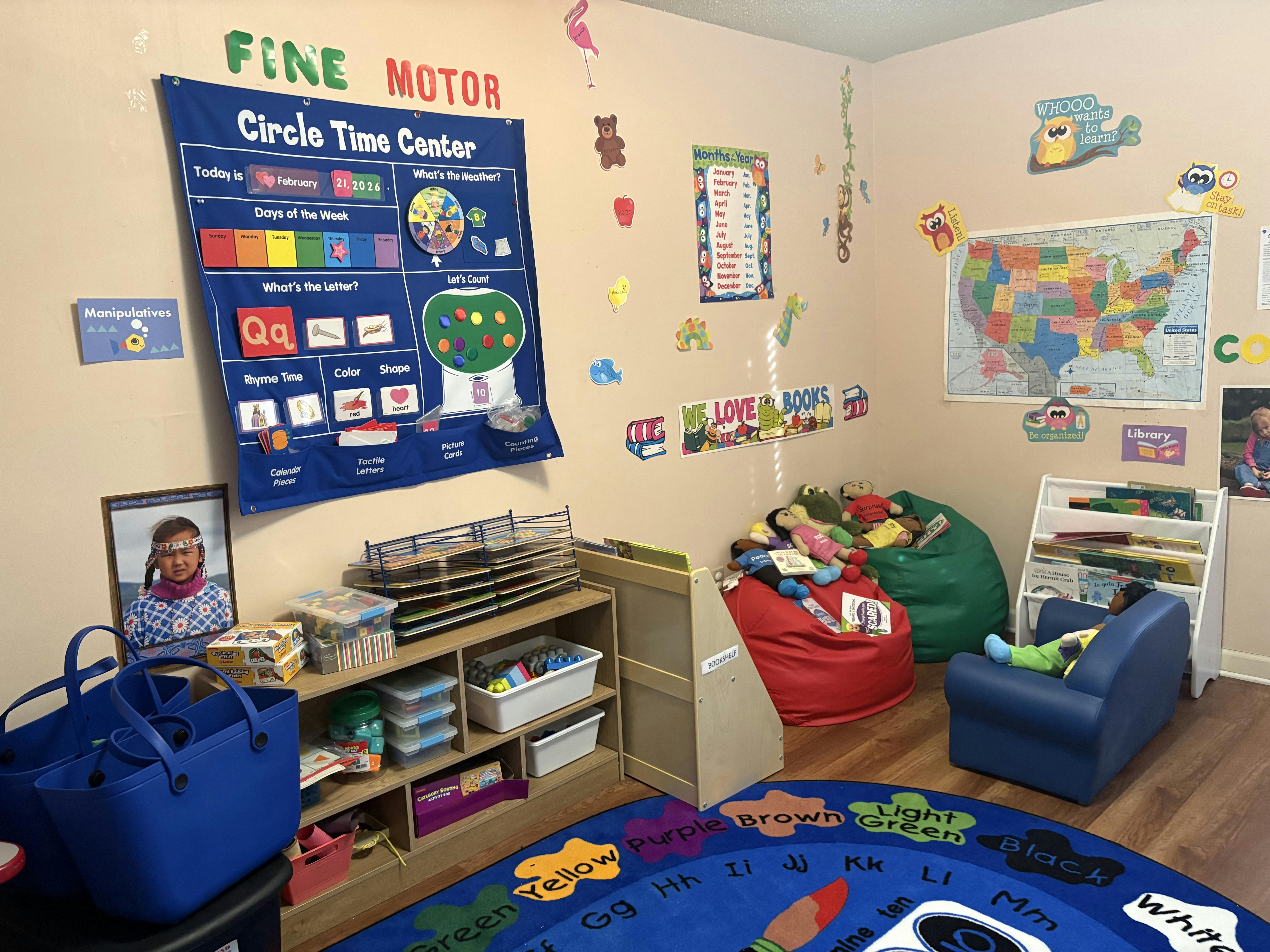 Classroom or play area with a circle time chart, US map, bookshelves, and beanbag chairs