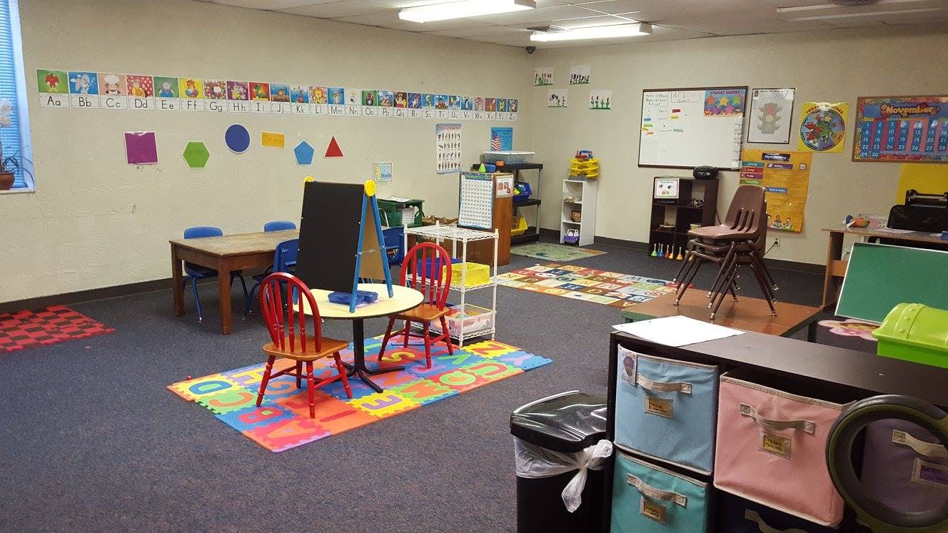 Classroom with small tables and chairs, alphabet and shapes on wall