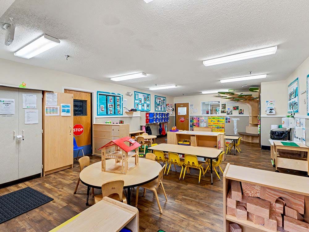 empty preschool classroom with small tables and chairs