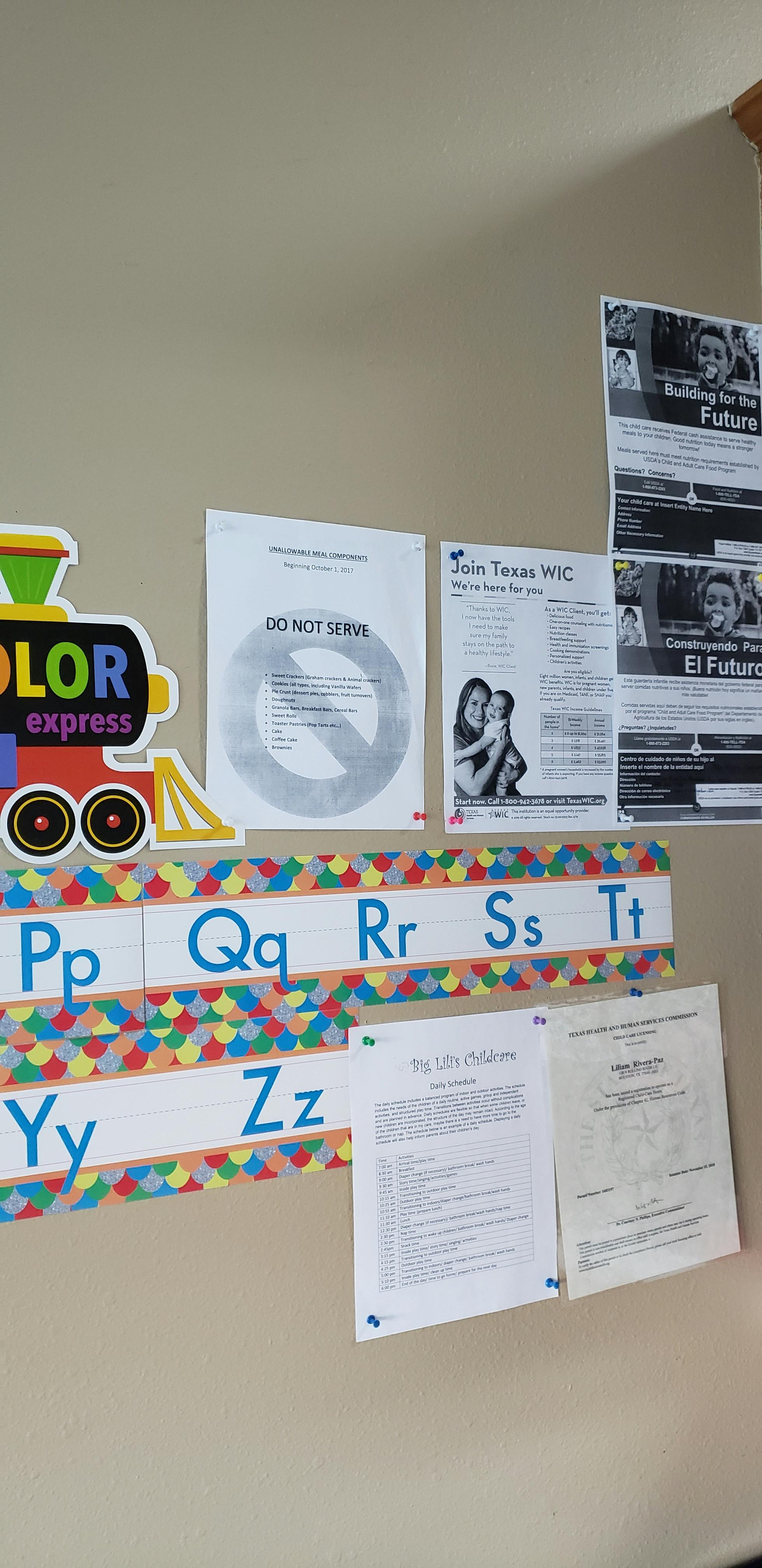 Wall with a colorful train cutout, alphabet letters, and various informational posters