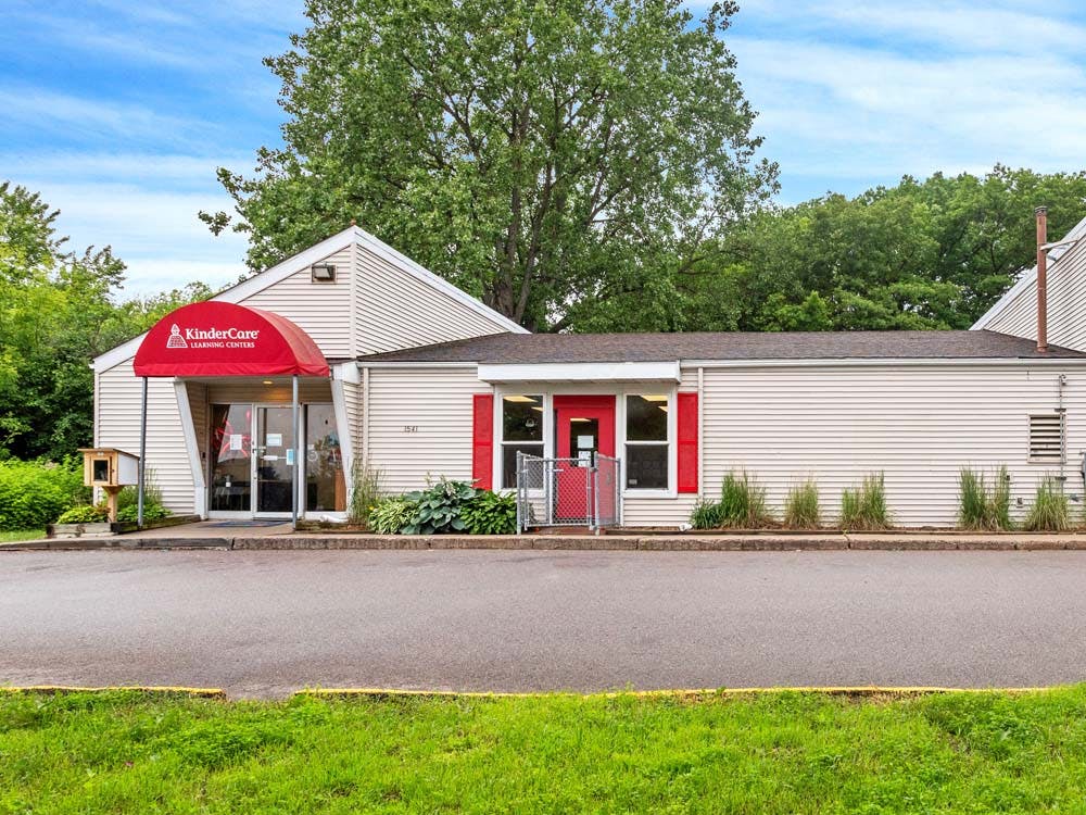 KinderCare Learning Centers building with a red awning and red window shutters