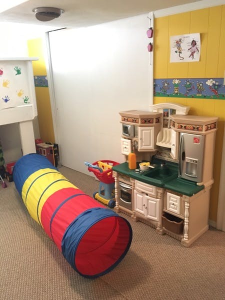 Play tunnel and toy kitchen in a room