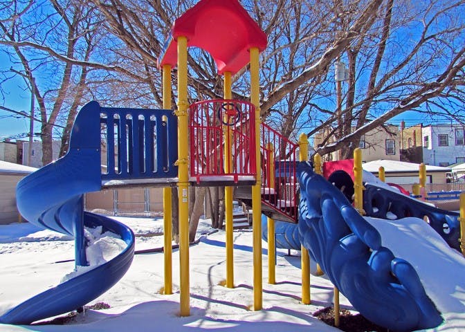 Playground with slides and climbing structures covered in snow