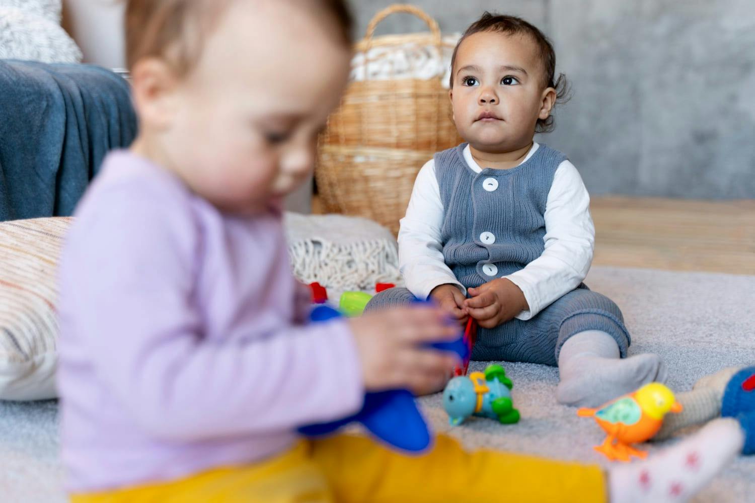 Two children sitting on the floor playing with toys