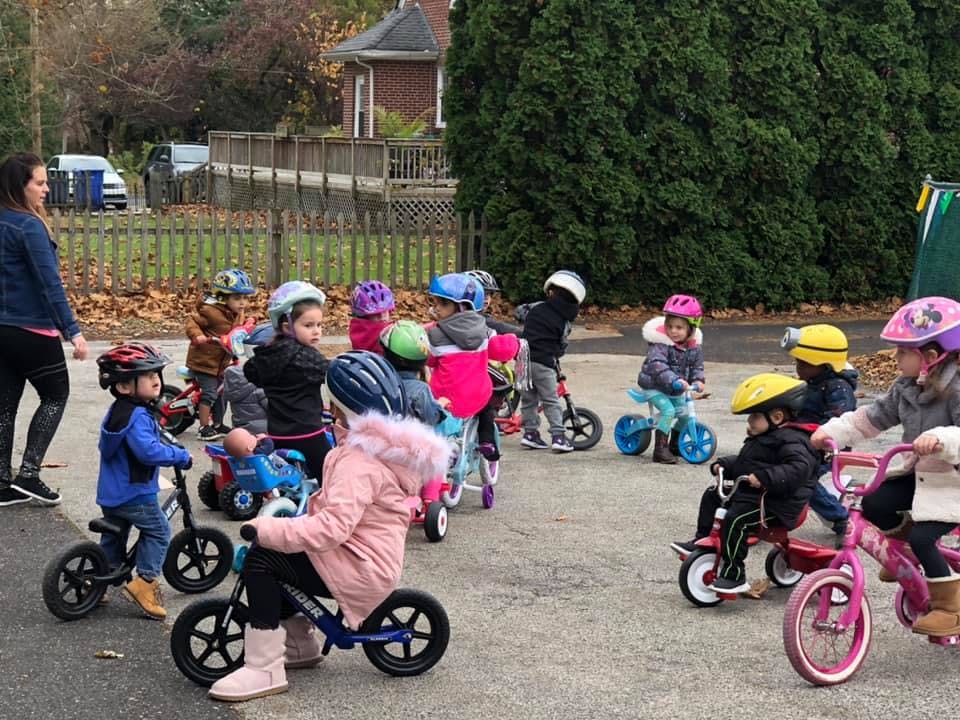 Adult supervising children on tricycles and balance bikes