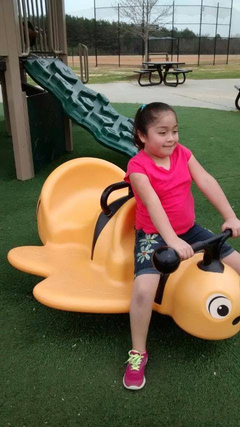 Child on a yellow spring rider in a playground