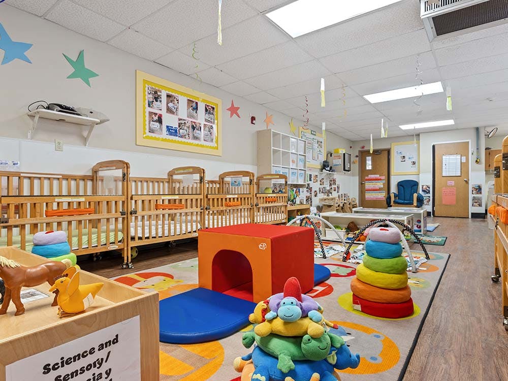 Cribs and play area in a daycare classroom