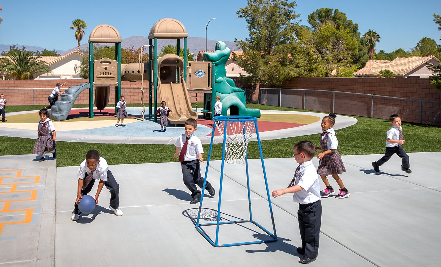 Children playing on a playground with a basketball hoop