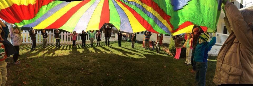 Children playing with a large colorful parachute