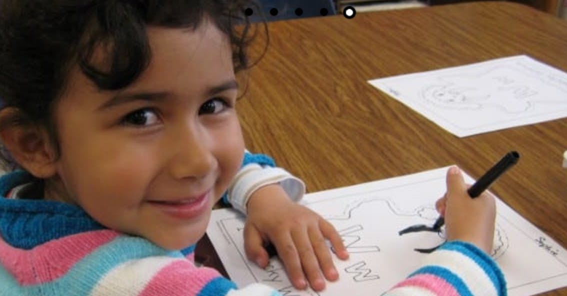 Child drawing on paper at a table
