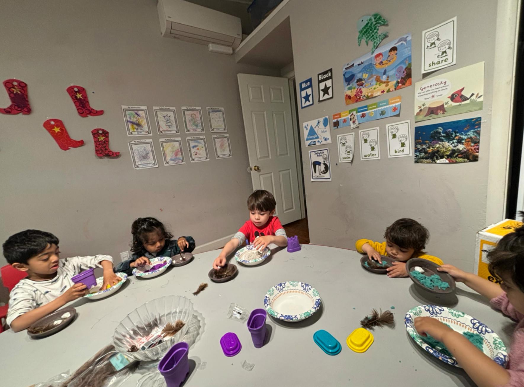 Children sitting at a table doing an activity with plates and small objects