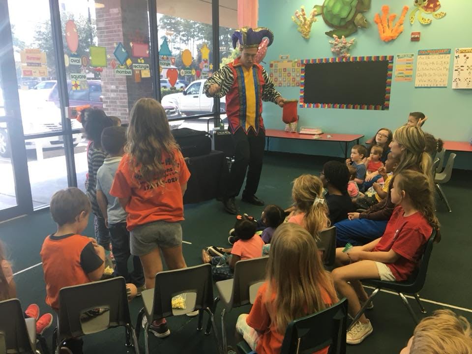 Person in jester hat performing for children