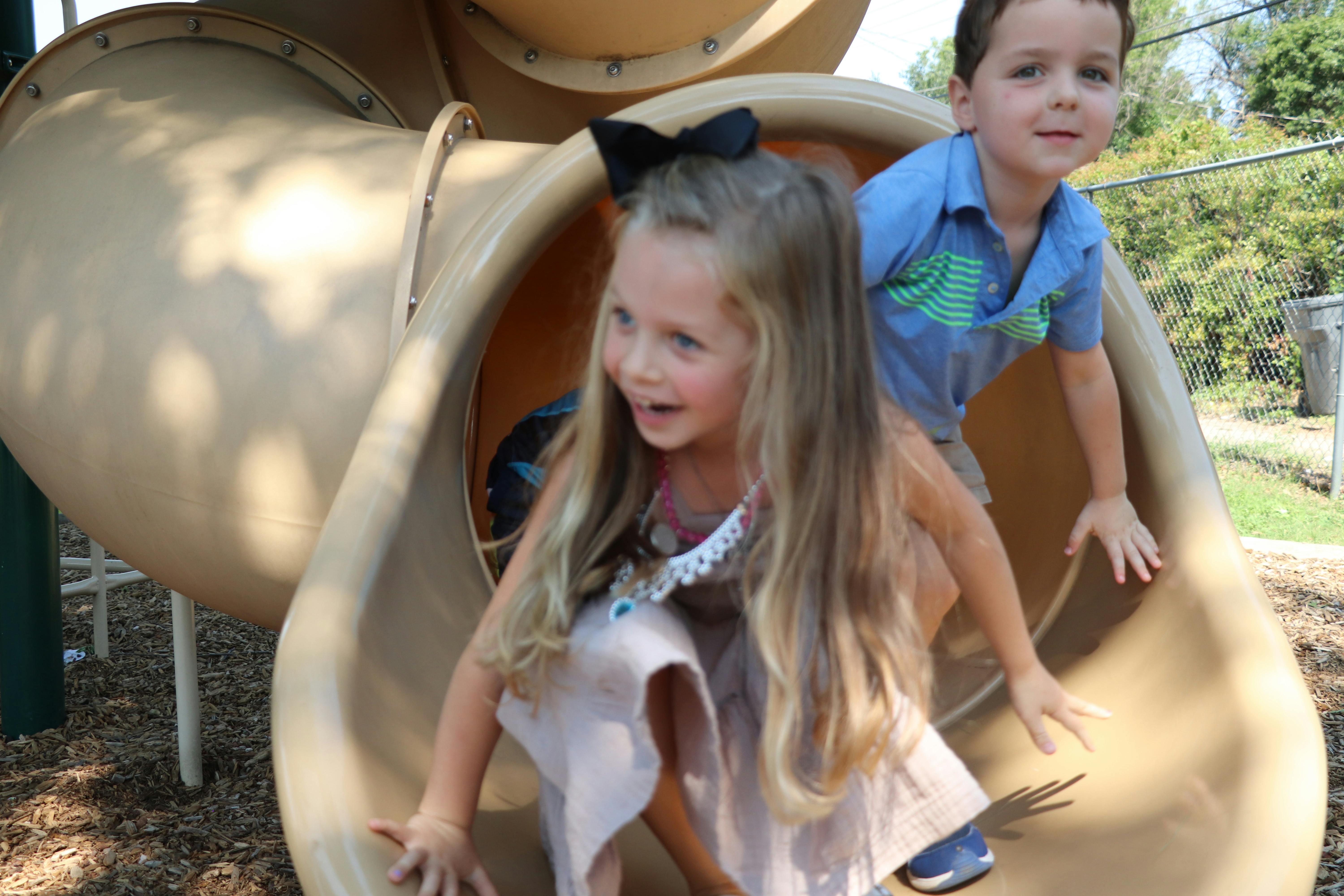 Two children on a playground slide