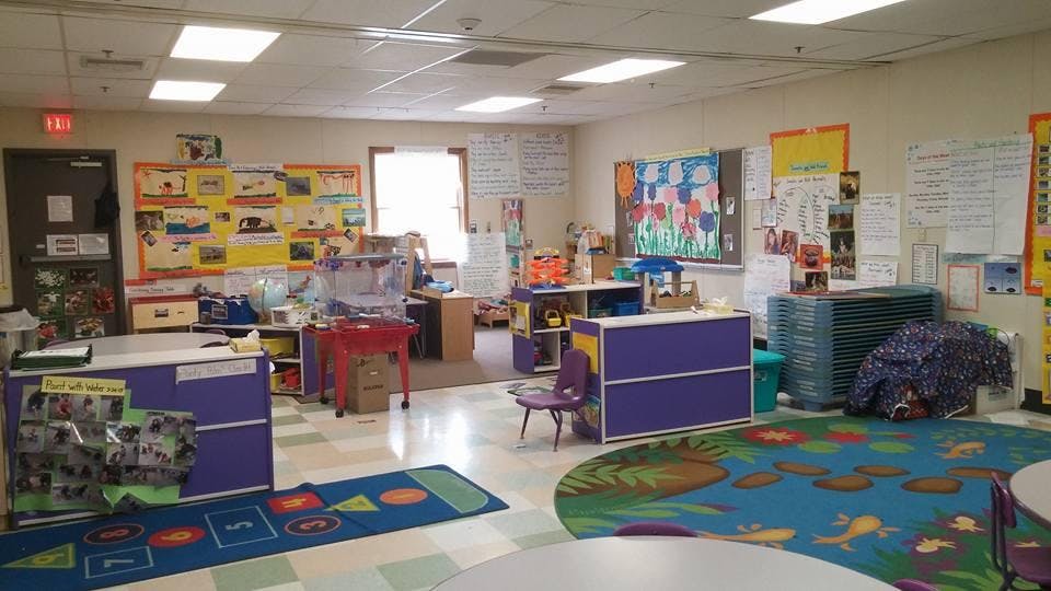 Classroom with child-level furniture, bulletin boards, and colorful rugs