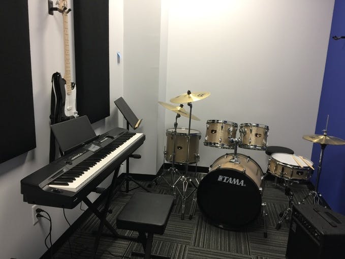 Music studio with a keyboard, drum set, and guitar