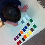 Child sorting colored blocks on a mat