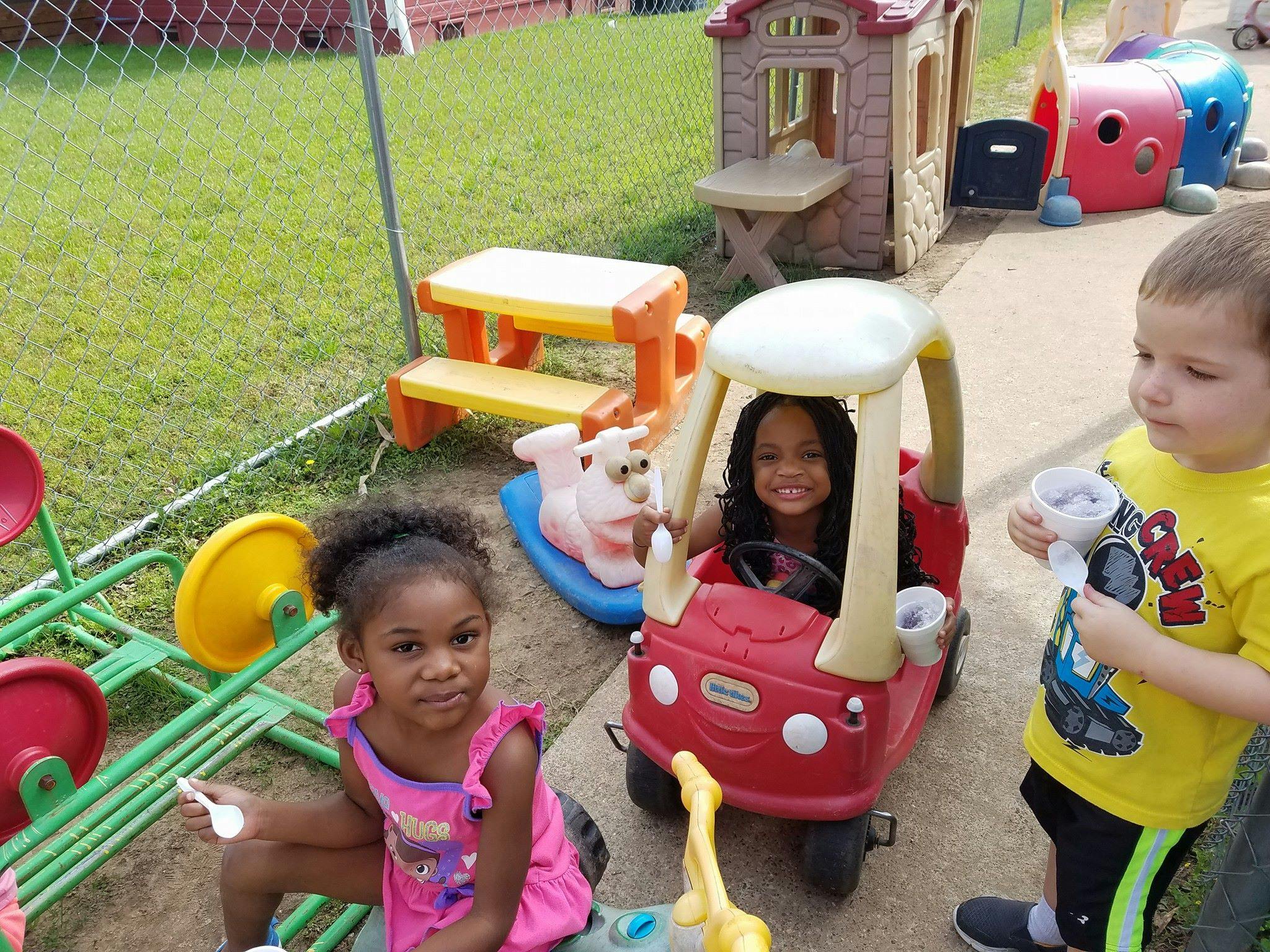 Three children playing with toys outdoors