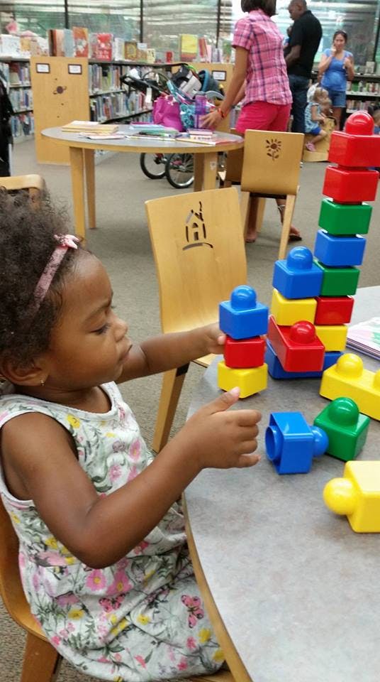 Child playing with colorful building blocks at a table