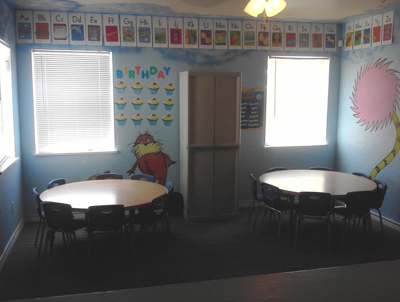 Classroom with two round tables and chairs, decorated walls