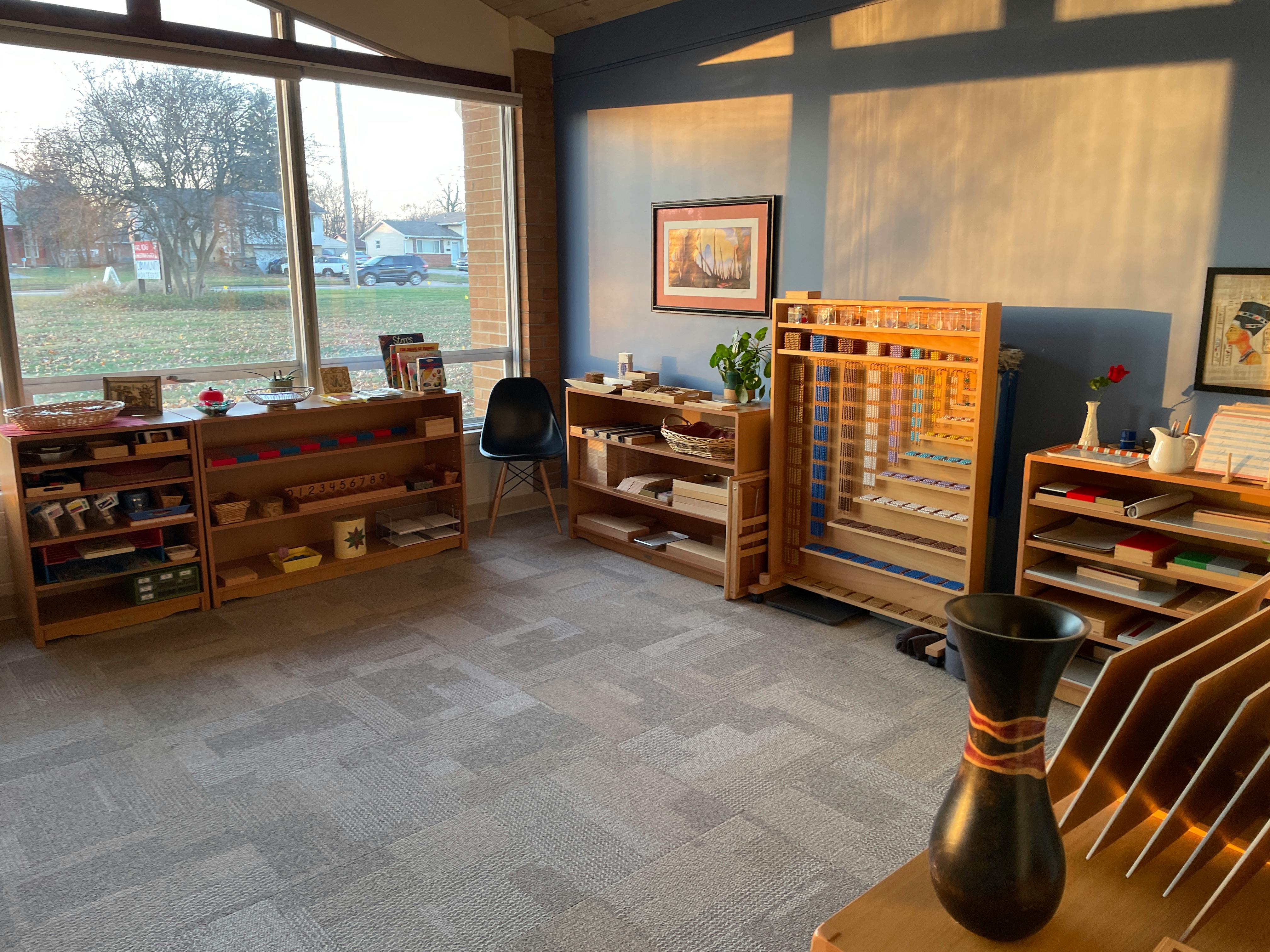 Classroom with wooden shelves and large windows
