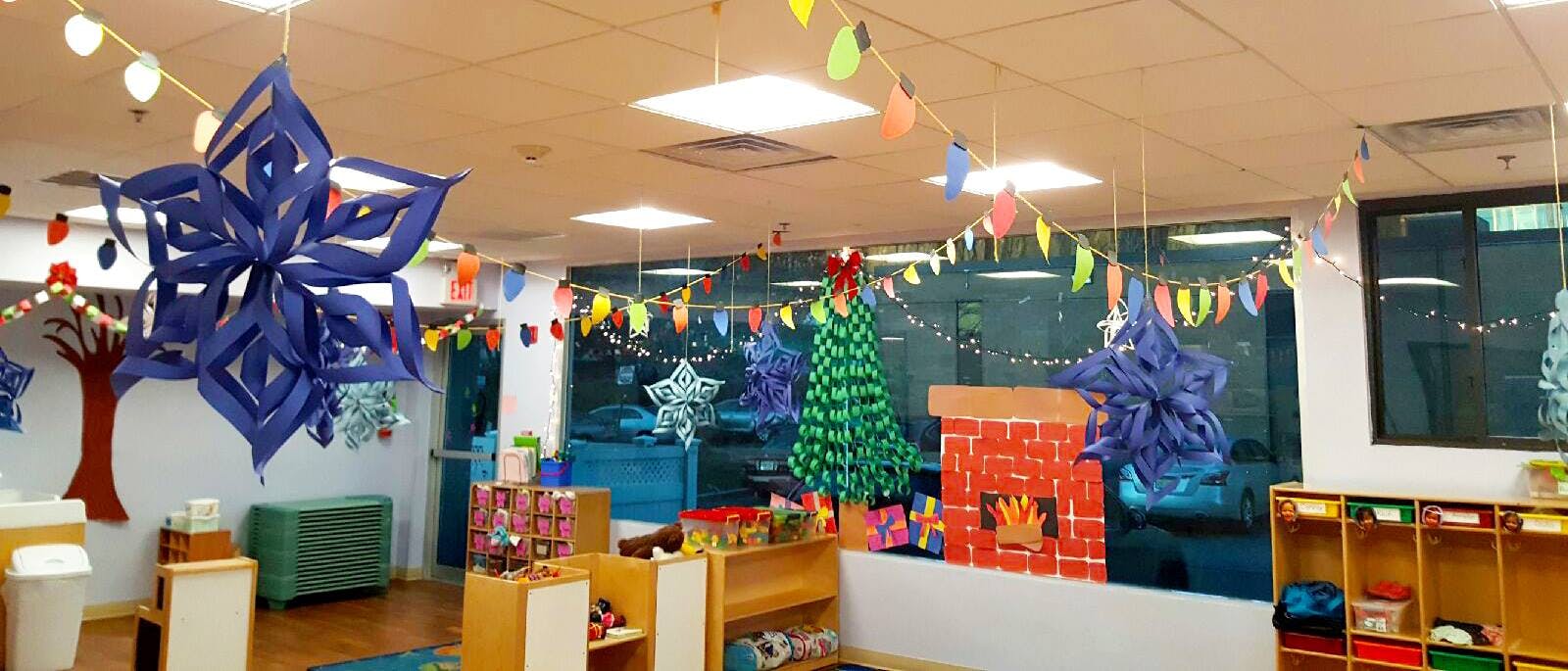 Classroom decorated with paper snowflakes, garlands, and a cardboard fireplace