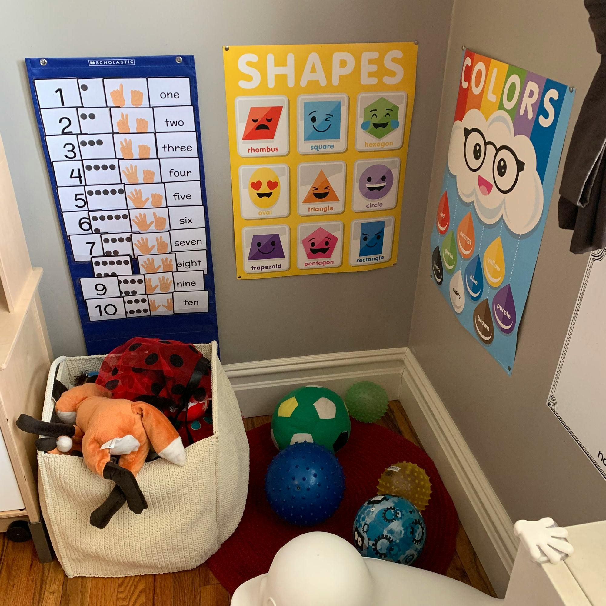 Educational posters for shapes, colors, and counting on a wall