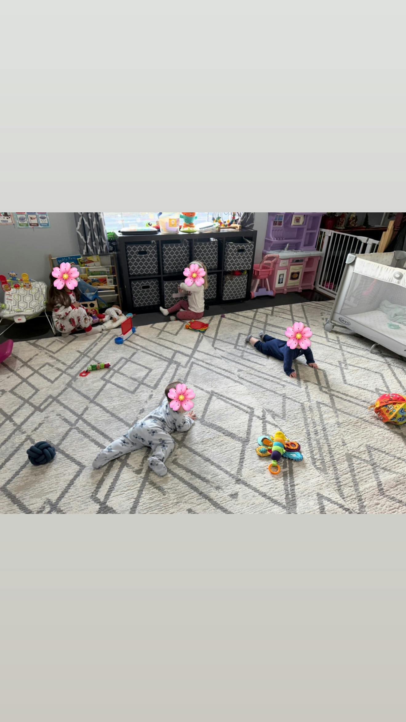 Several children playing in a room with toys on the floor