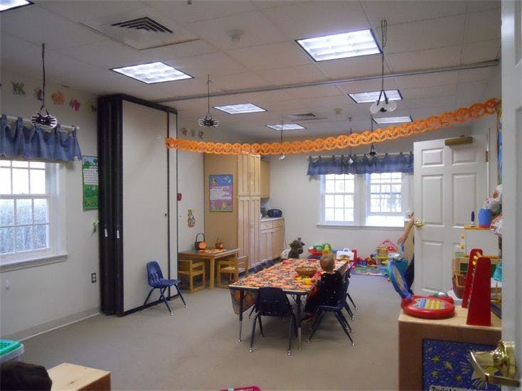 Classroom with tables and chairs, decorated with orange streamers