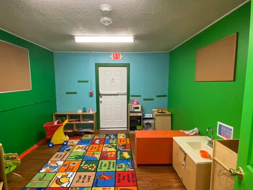 Playroom with colorful rug, shelves, and small sink