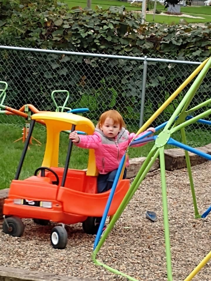 Child in a toy car on a playground