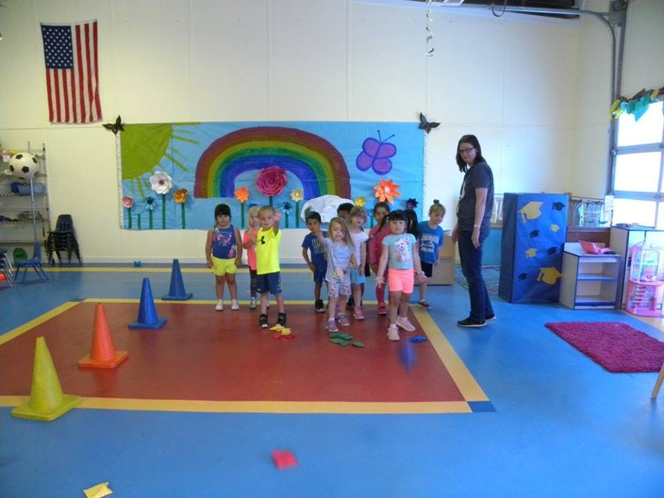 Person with a group of children in a classroom