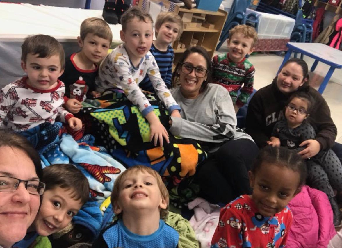 Group of adults and children sitting together with blankets